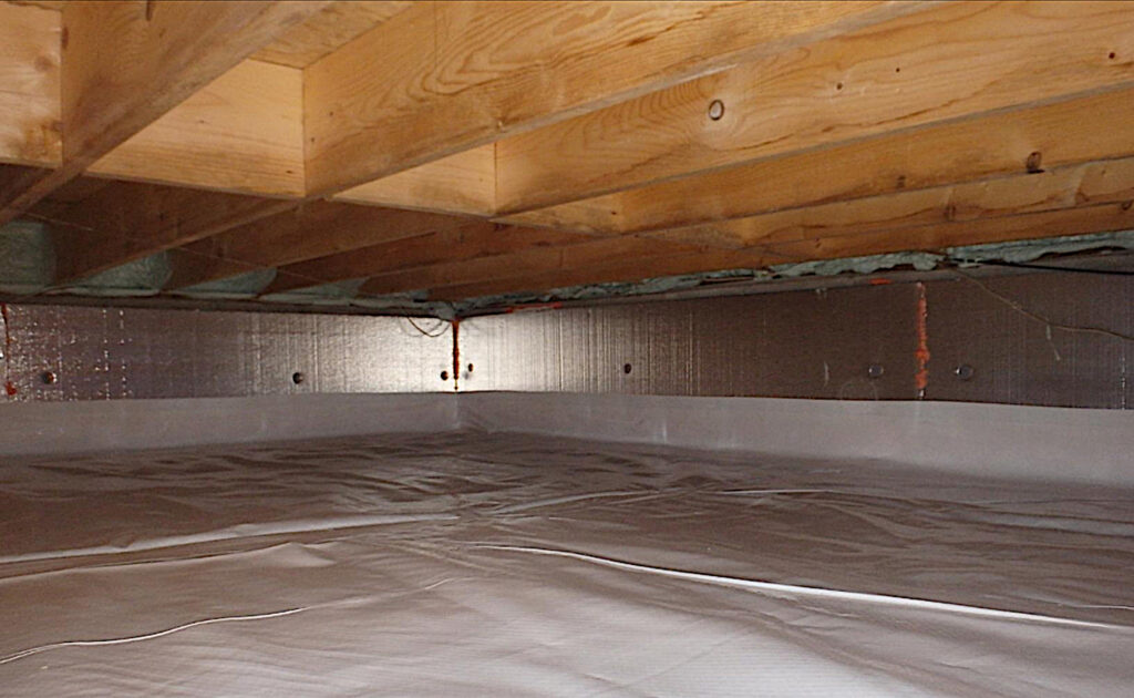 Atlantic crawl space encapsulation showing sealed plastic vapor barrier on the ground with insulated walls and exposed wooden floor joists above.